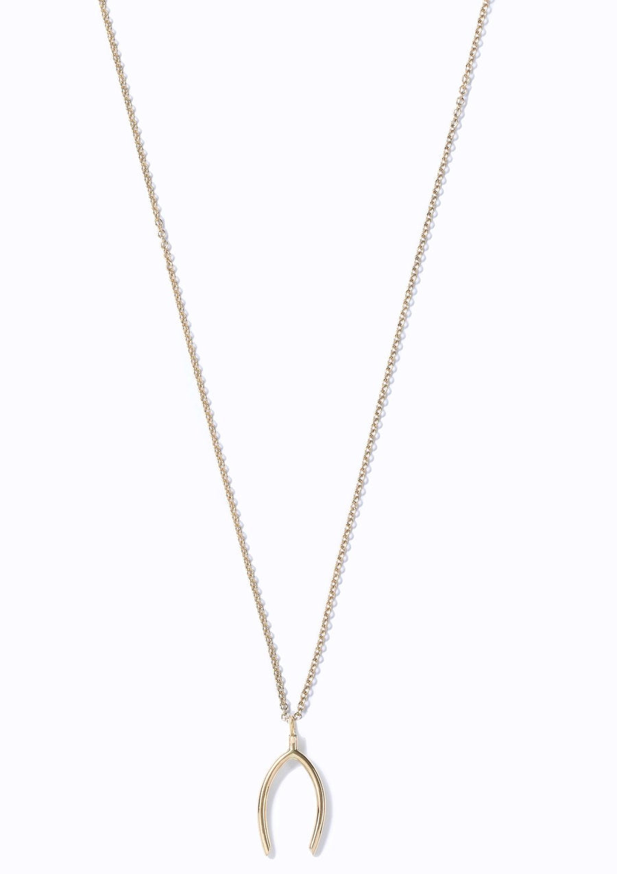 Gold wishbone pendant necklace on a white background